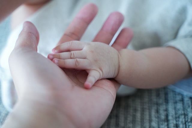 a mum and her baby holding hands